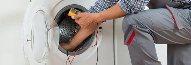 Dryer repair technician inspecting and repairing a clothes dryer in Phoenix, AZ