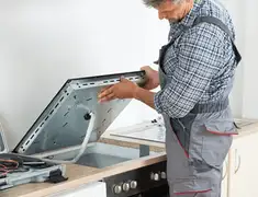Appliance repair technician installing a built-in cooktop in Phoenix, AZ