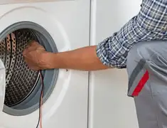 Dryer repair technician diagnosing and servicing a clothes dryer in Phoenix, AZ