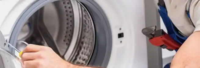 Appliance technician repairing a clothes dryer drum and internal parts in Phoenix, AZ