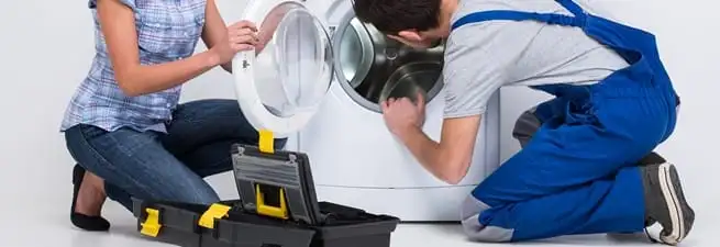 Washer repair technician inspecting a front-load washing machine with tools in Phoenix, AZ