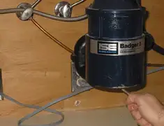 Garbage disposal repair technician tightening the mounting ring under a sink in Phoenix, AZ