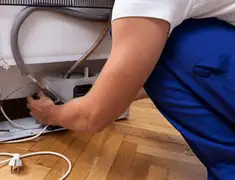 Appliance repair technician fixing refrigerator water line and connections in Phoenix, AZ