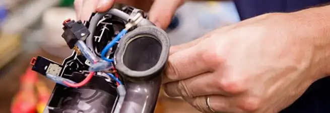 Vacuum repair technician reconnecting wiring and components in Phoenix, AZ