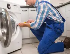 Washing machine repair technician servicing a front-load washer in Phoenix, AZ