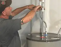 Water heater repair technician tightening supply line connections in Phoenix, AZ