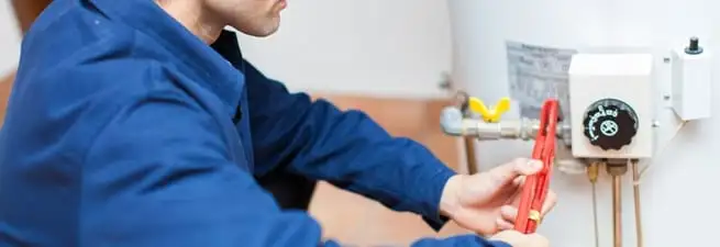 Water heater repair technician adjusting the temperature control and gas valve in Phoenix, AZ